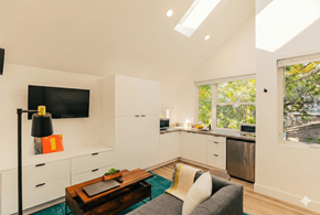 Oakland apartment for rent - A modern kitchen with white cabinets and a flat screen TV mounted on the wall.