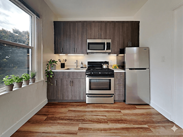 Oakland apartment for rent - A kitchen with a stove top oven and a refrigerator.
