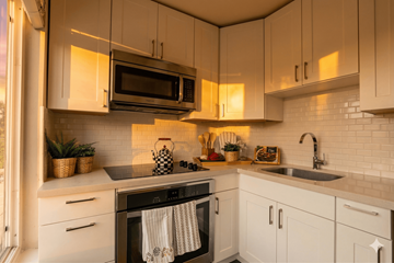 Oakland apartment for rent - A kitchen with white cabinets and a black stove top oven.