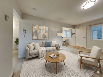 Oakland apartment for rent - A living room with a grey couch, a wooden coffee table, and a painting on the wall.