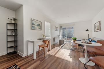 Oakland apartment for rent - A living room with a white table and a brown chair.