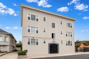 Oakland apartment for rent - A large, two-story building with a black door and windows on the front.