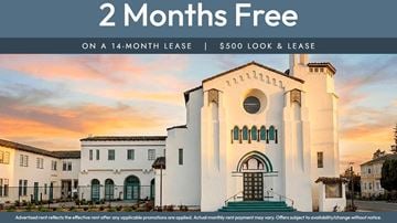 Oakland apartment for rent - A white building with a large arched doorway and a balcony is advertised as having 2 months free on a 14-month lease.