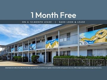 Oakland apartment for rent - A building with a mural of a bird on it is advertising a free month on a 12-month lease.
