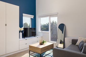 Oakland apartment for rent - A modern living room with a grey sofa and a wooden coffee table.