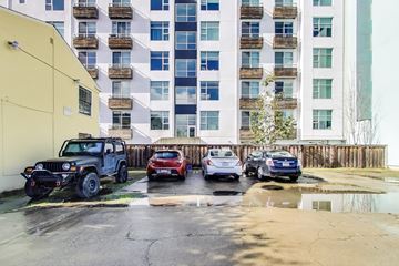 Berkeley apartment for rent - A black jeep is parked in front of a yellow building.