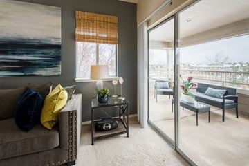 Greenwood Village apartment for rent - A living room with a grey couch, a table with a lamp and a painting on the wall.