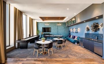 Oakland apartment for rent - A modern living room with a pool table and a kitchen area.