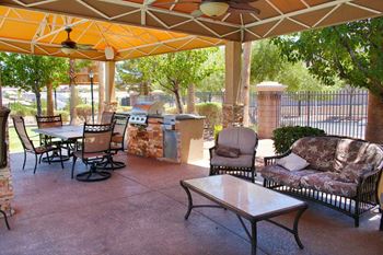 A patio with a table and chairs under a canopy.