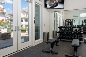 Roseville townhouse for rent - A home gym with a row of dumbbells and a bench.
