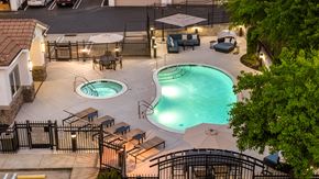 Roseville townhouse for rent - A pool area with two pools and a hot tub surrounded by a fence.