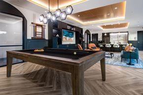 Bothell apartment for rent - A pool table with a blue rug and a chairs.