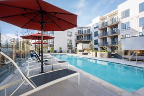 Pleasant Hill apartment for rent - A red umbrella is on a poolside table.