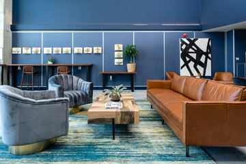 Oakland apartment for rent - a living room with blue walls and leather couches and chairs