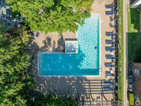 Killeen apartment for rent - An aerial view of a swimming pool surrounded by trees and lounge chairs.