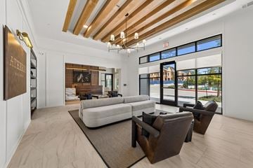 Mckinney apartment for rent - A modern living room with a white sofa and brown chairs.