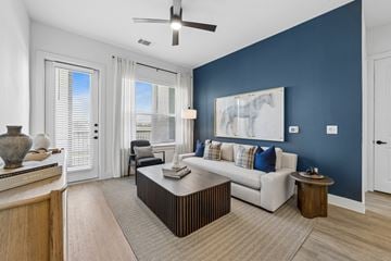 Mckinney apartment for rent - A living room with a white couch and a ceiling fan.