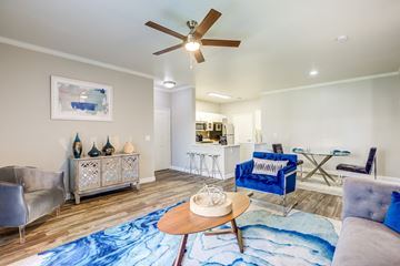 Henderson apartment for rent - A living room with a blue rug and a ceiling fan.