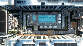 Mountain View apartment for rent - A modern building with a pool and a glass wall.