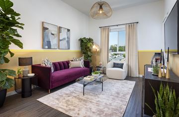 Los Angeles apartment for rent - A living room with a purple couch and a white chair.