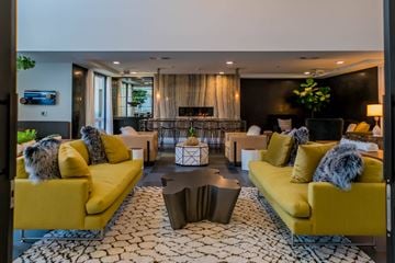 Costa Mesa apartment for rent - A living room with yellow couches and a patterned rug.