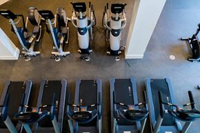 Costa Mesa apartment for rent - A row of treadmills and exercise bikes are lined up in a gym. at Baker Block, California