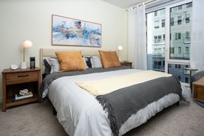Redmond townhouse for rent - A bedroom with a large bed, a nightstand, and a painting on the wall.