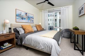 Redmond townhouse for rent - A bedroom with a large bed and a ceiling fan.