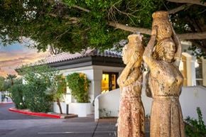 Scottsdale apartment for rent - A statue of a woman holding a child stands in front of a building.