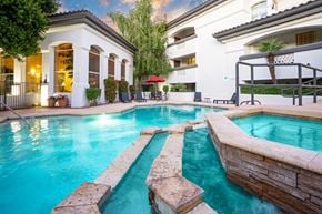 Scottsdale apartment for rent - A swimming pool with a stone border and a building with a balcony in the background.