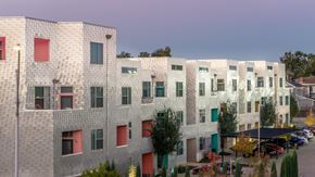 Oklahoma City apartment for rent - A modern building with a grey facade and red and green accents.