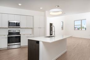 Oklahoma City apartment for rent - A modern kitchen with white cabinets and a wooden island.