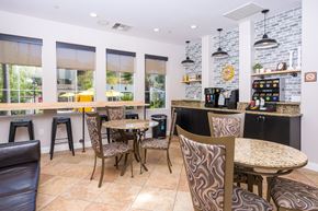 Upland apartment for rent - a seating area with tables and chairs in front of a counter with a coffee machine and a