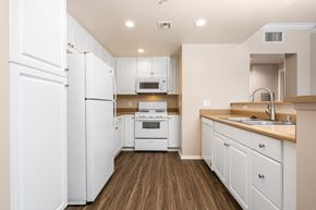 Upland apartment for rent - a kitchen with white cabinets and white appliances