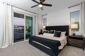 Lincoln apartment for rent - 3-Bedroom Homes for Rent in Lincoln, CA - Cyrene at Meadowlands - Bedroom With Upholstered Bed, Nightstands, Lamps, Windows, Carpet Flooring, and Sliding Glass Doors.