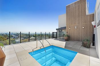 A small pool in a patio with a view of the city.