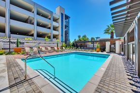 Ontario apartment for rent - A swimming pool surrounded by a brick walkway and a metal fence.