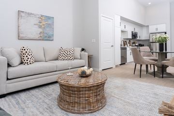 Ontario apartment for rent - A living room with a grey couch and a wicker coffee table.
