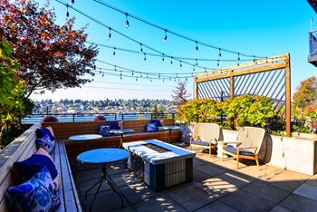 A patio with a table, chairs, and a hot tub.