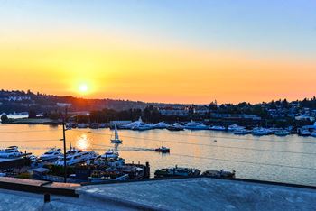 A sunset over a marina with boats docked in the water.