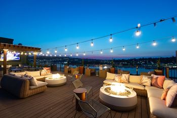 A rooftop patio with a fire pit and seating area.