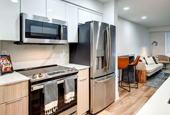 A modern kitchen with a stove top oven and a refrigerator.