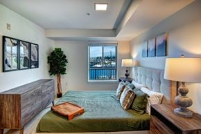 Seattle apartment for rent - A bedroom with a large bed and a view of the city.