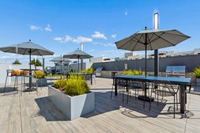 Oakland apartment for rent - A patio with a table, chairs, and umbrellas.