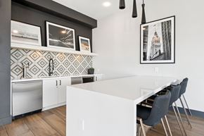 Oakland apartment for rent - A kitchen with a white counter and grey chairs.