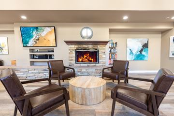 Pasadena apartment for rent - A living room with a stone fireplace and a television mounted on the wall.