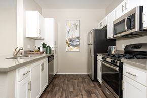 Valencia apartment for rent - a kitchen with stainless steel appliances and white cabinets at 55+ FountainGlen Valencia, Valencia, California