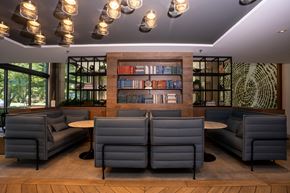 Sacramento apartment for rent - A modern lounge area with grey couches and a bookshelf filled with books.
