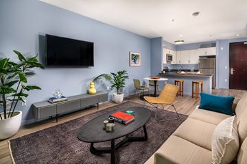 Los Angeles apartment for rent - A living room with a couch, a coffee table, and a television mounted on the wall.