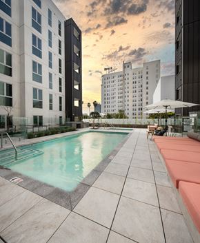 Los Angeles apartment for rent - A swimming pool surrounded by buildings and lounging areas.